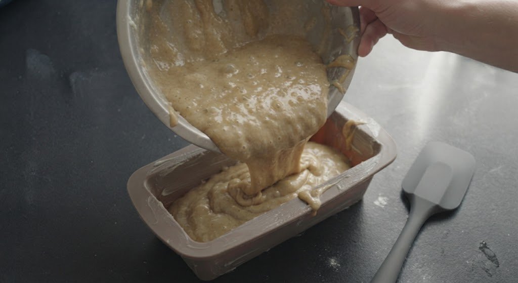 Vertiendo la masa de pan de plátano en un molde de silicona