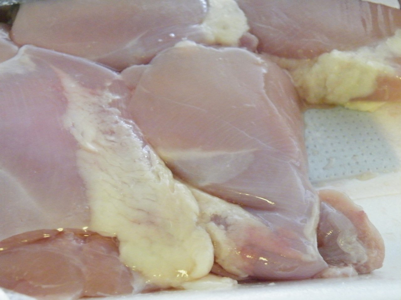 Contramuslos de pollo crudos sobre una bandeja