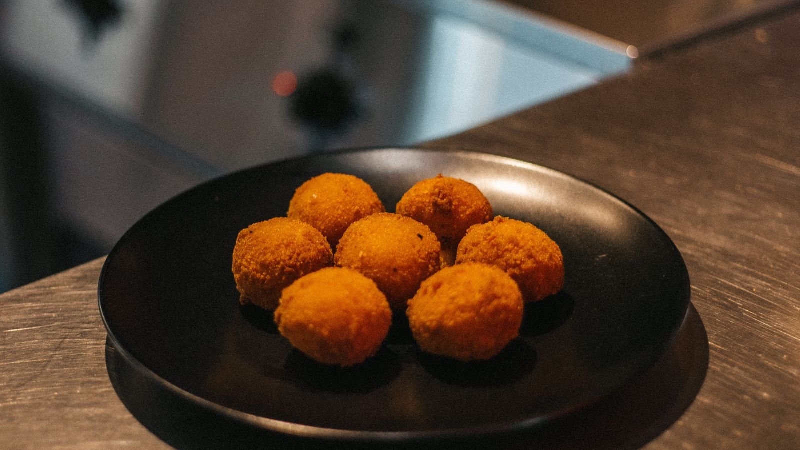 Bolitas fritas doradas en un plato (imagen de referencia)