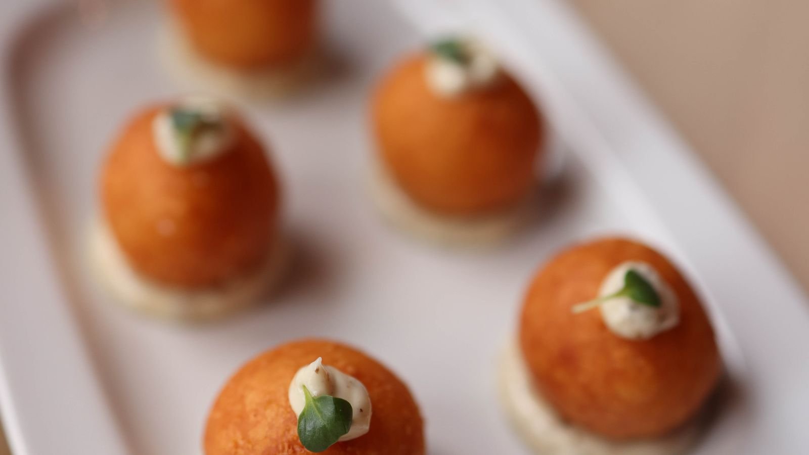 Bolitas empanadas doradas con salsa (imagen de referencia)