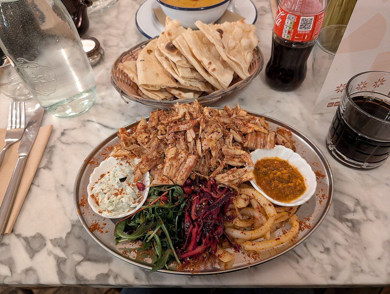 Plato de shawarma de pollo con pan lavash, bulgur y ensaladas